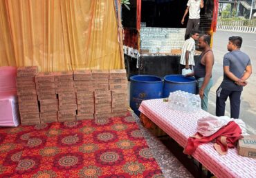 Jan Sewa Trust volunteers unloading bottled water next to a red carpet