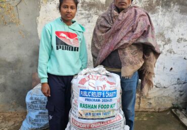 Jan Sewa Trust food kit distribution: Man & woman with ration bags