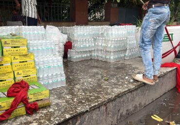 Jan Sewa Trust portfolio: stacked water bottles and supplies for distribution.