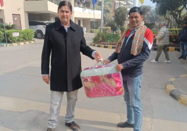 Two men in an apartment complex courtyard, one giving a blanket to the other.
