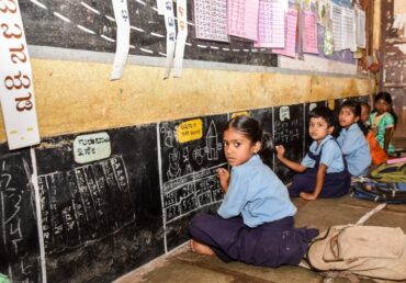 Children learning at a blackboard in a Jan Sewa Trust classroom.
