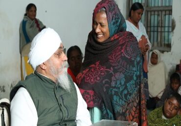 Jan Sewa Trust NGO: Man in turban speaking to women, social welfare.