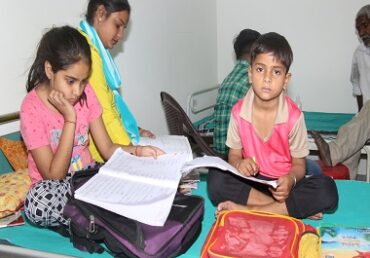 Children study in a hospital ward, supported by Jan Sewa Trust NGO.
